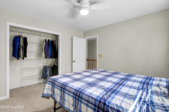 bedroom featuring carpet flooring, a textured ceiling, ceiling fan, and a closet