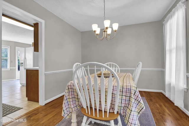 dining room featuring hardwood / wood-style floors, a textured ceiling, and a chandelier