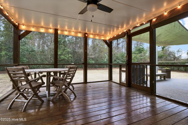 unfurnished sunroom featuring ceiling fan and a wealth of natural light