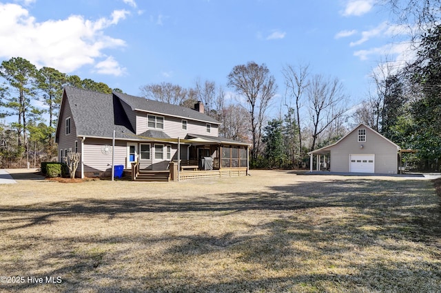 view of front of house featuring a porch, a garage, an outbuilding, a front yard, and a sunroom