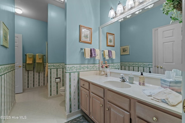 bathroom with tile patterned flooring, vanity, and toilet