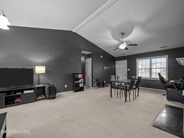 dining area featuring ceiling fan, carpet floors, and vaulted ceiling with beams