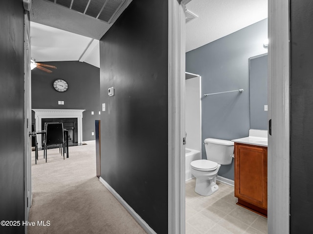 bathroom featuring vanity, vaulted ceiling, ceiling fan, and toilet