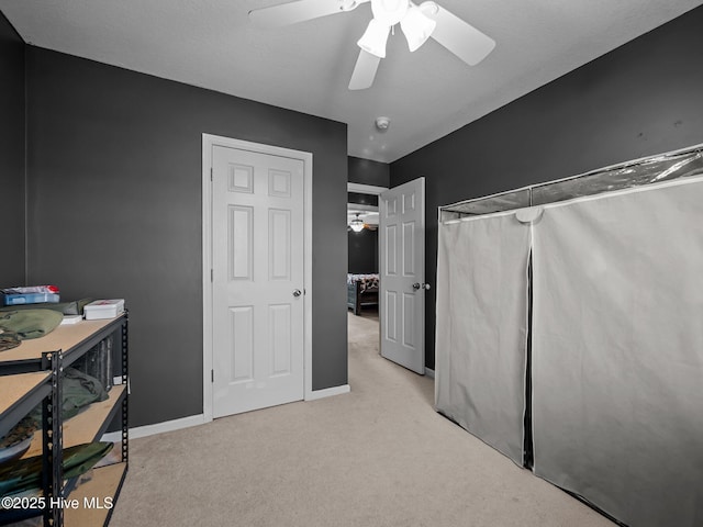 interior space with light colored carpet and ceiling fan