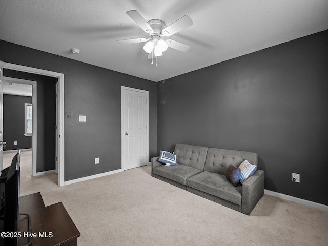 carpeted living room featuring ceiling fan and a textured ceiling