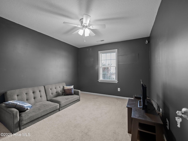 carpeted living room featuring a textured ceiling and ceiling fan