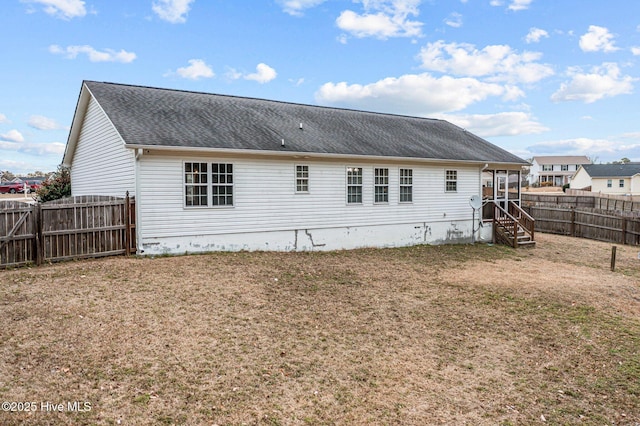 rear view of property with a yard