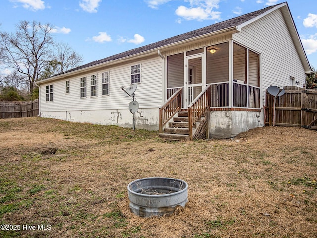 rear view of property with a lawn and an outdoor fire pit