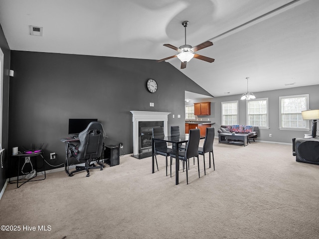 carpeted dining room with vaulted ceiling and ceiling fan with notable chandelier