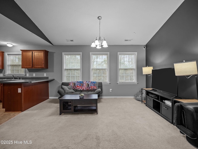 living room featuring vaulted ceiling, a healthy amount of sunlight, and light colored carpet