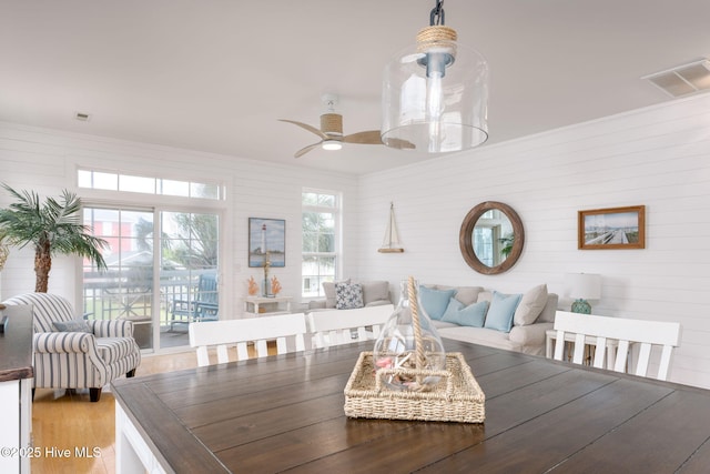 dining room with wood-type flooring, ornamental molding, and ceiling fan