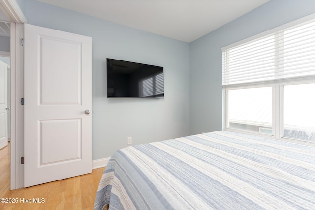 bedroom featuring light hardwood / wood-style floors and multiple windows