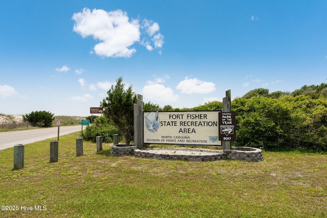 community / neighborhood sign featuring a lawn