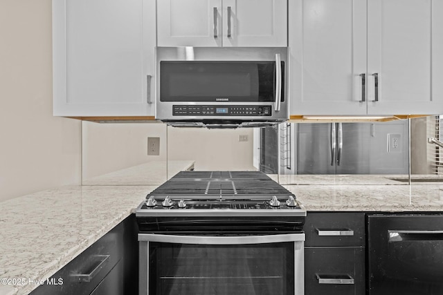 kitchen featuring white cabinetry, appliances with stainless steel finishes, and beverage cooler