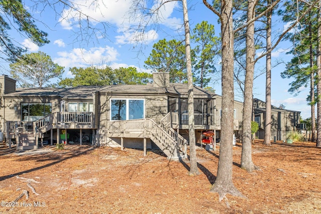 back of property featuring a deck and a sunroom