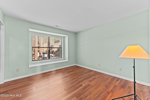 unfurnished room with hardwood / wood-style flooring