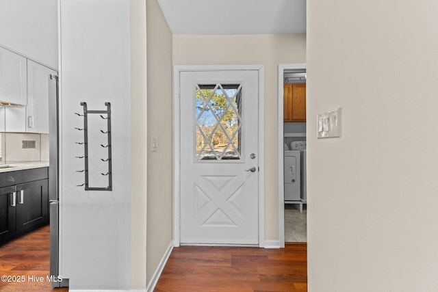 doorway with dark wood-type flooring and washer and dryer