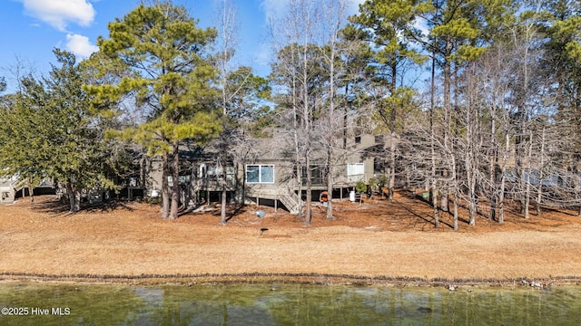 rear view of house featuring a deck with water view