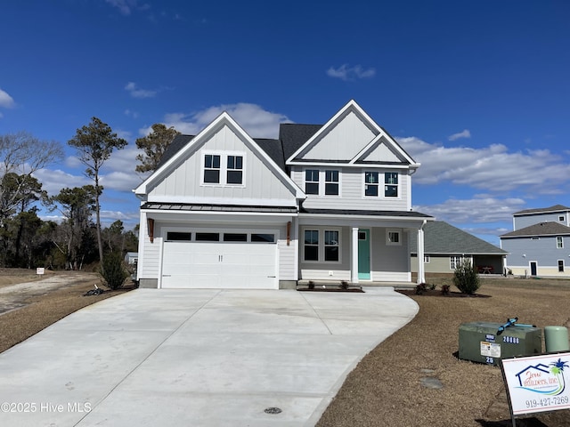 view of front facade with concrete driveway, an attached garage, board and batten siding, a standing seam roof, and metal roof