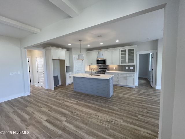 kitchen featuring dark wood-style flooring, white cabinetry, stainless steel appliances, and a sink