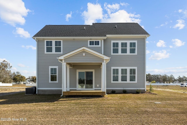 rear view of house with cooling unit and a yard