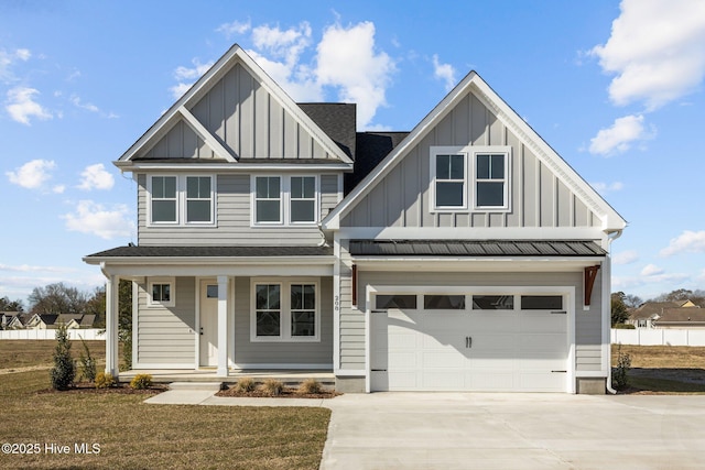 view of front of property with a garage, covered porch, driveway, roof with shingles, and board and batten siding