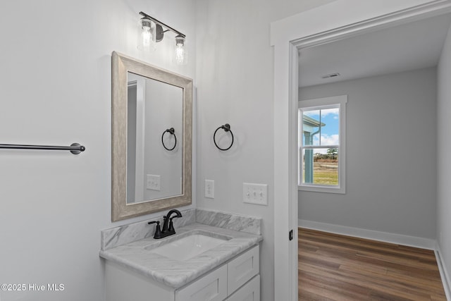 bathroom featuring visible vents, vanity, baseboards, and wood finished floors