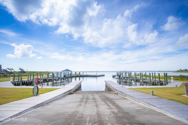 view of dock with a water view and a yard