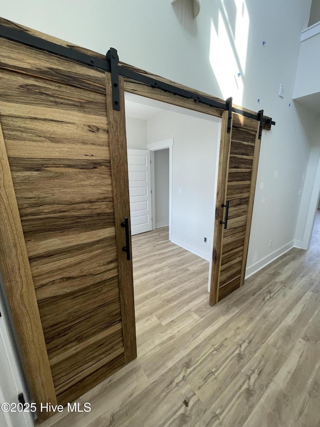 interior space with a barn door and light hardwood / wood-style flooring