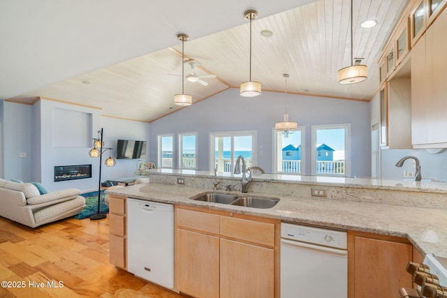 kitchen with light stone counters, white dishwasher, sink, and light wood-type flooring