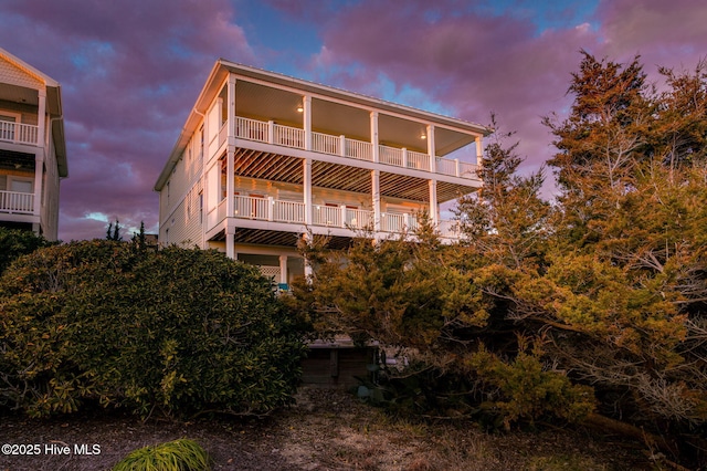 back house at dusk featuring a balcony