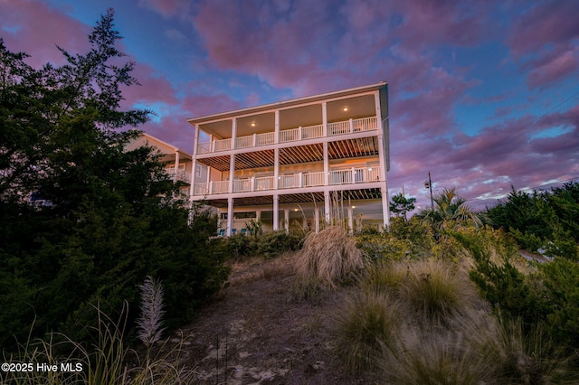 back house at dusk featuring a balcony