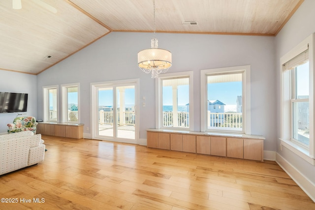 interior space featuring crown molding, lofted ceiling, light hardwood / wood-style flooring, and a notable chandelier