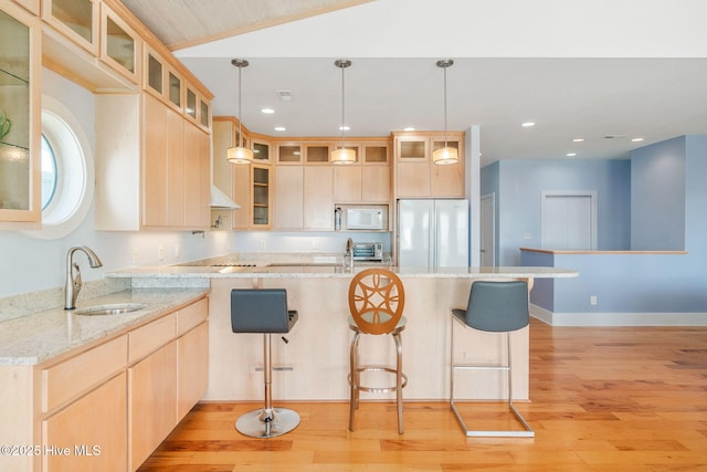 kitchen with sink, pendant lighting, light brown cabinetry, and white appliances