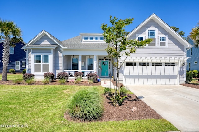 view of front facade featuring covered porch, driveway, a front yard, and a garage