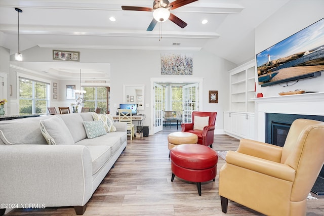 living area with lofted ceiling with beams, plenty of natural light, and wood finished floors