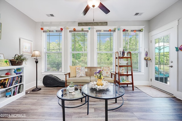 sunroom / solarium featuring a ceiling fan, visible vents, and plenty of natural light