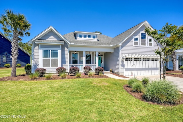 view of front of house with a porch, a garage, driveway, and a front lawn