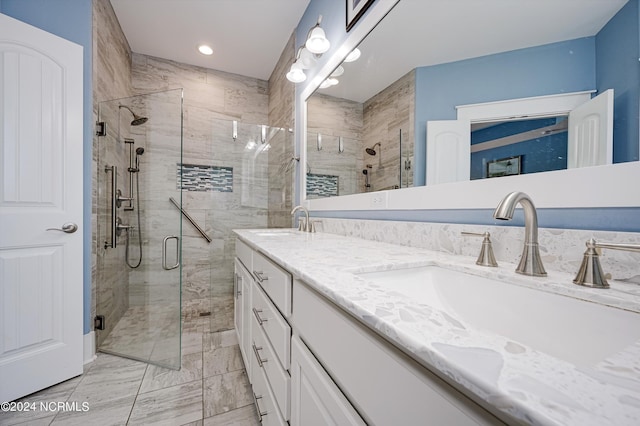 bathroom featuring double vanity, a shower stall, and a sink