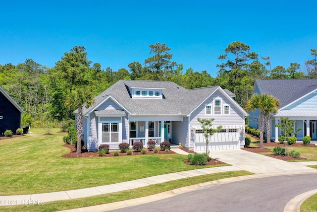 view of front of property with a shingled roof, concrete driveway, an attached garage, covered porch, and a front lawn