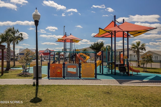 community jungle gym featuring a yard and fence