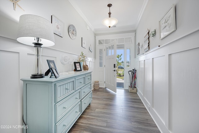 foyer with a wainscoted wall, ornamental molding, a decorative wall, and dark wood finished floors