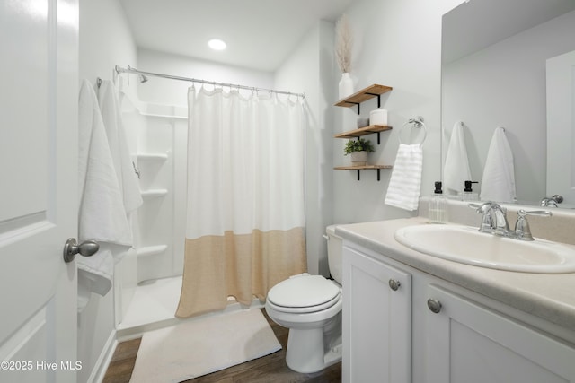 bathroom featuring curtained shower, vanity, toilet, and wood finished floors