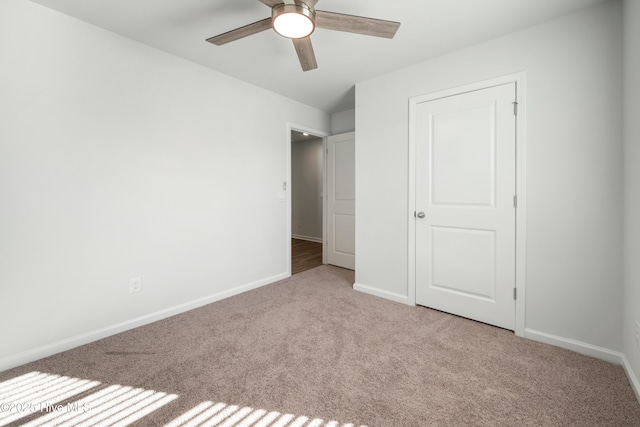 unfurnished bedroom featuring light colored carpet and ceiling fan