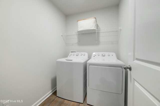 laundry room with laundry area, independent washer and dryer, baseboards, and wood finished floors