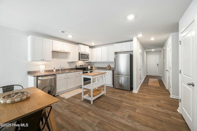 kitchen featuring recessed lighting, dark wood-style flooring, visible vents, white cabinetry, and appliances with stainless steel finishes