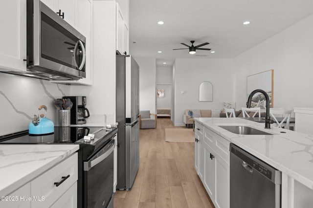 kitchen featuring light stone countertops, appliances with stainless steel finishes, sink, and white cabinets