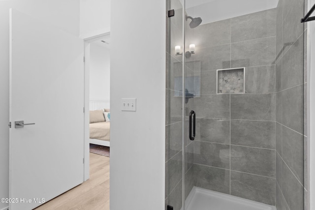 bathroom featuring wood-type flooring and an enclosed shower