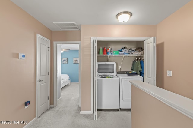 laundry room featuring light colored carpet and washing machine and clothes dryer