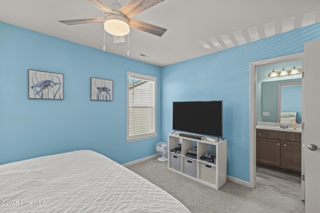 carpeted bedroom with sink, ensuite bath, and ceiling fan